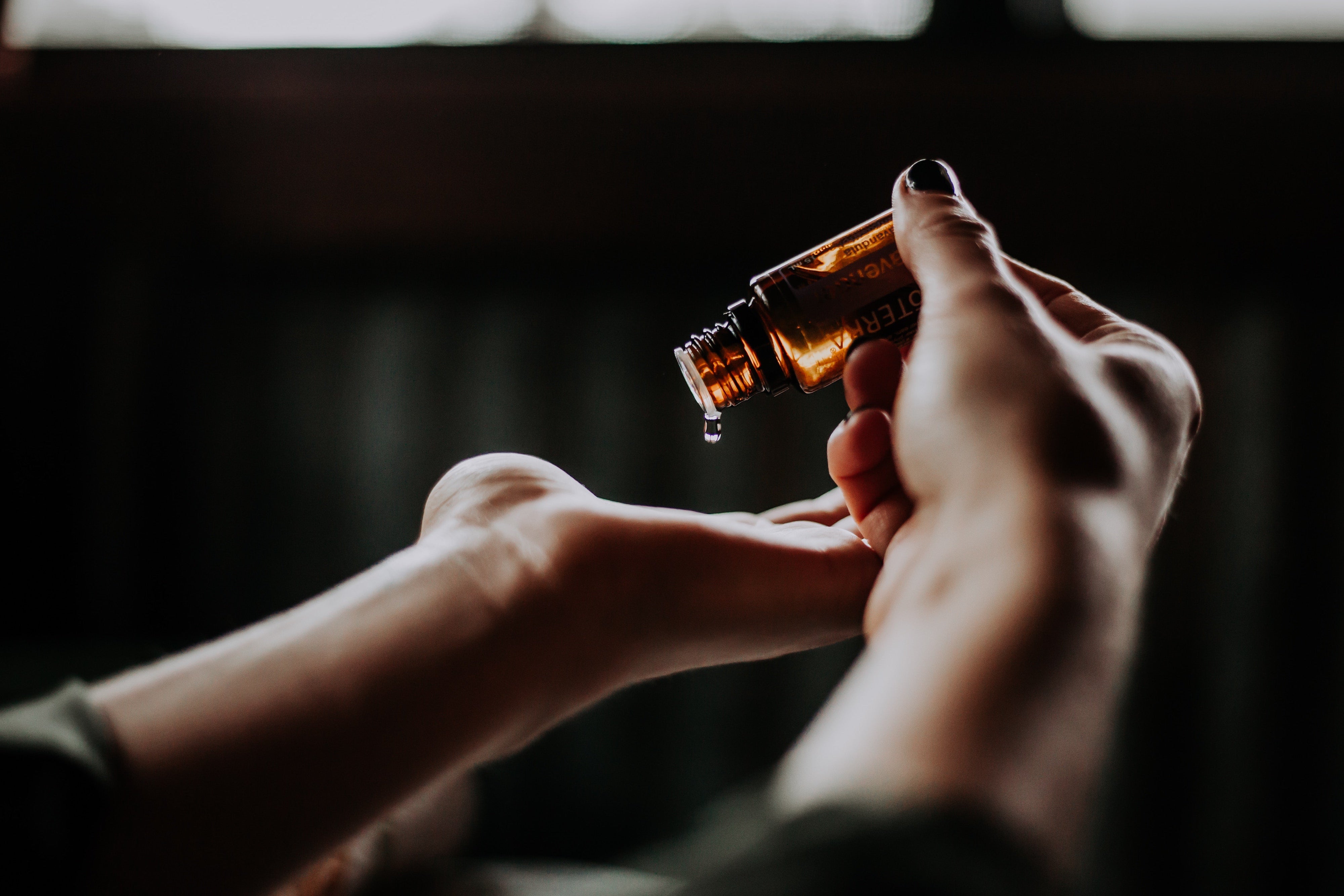 Person dropping massage oil into hands for perineal massage