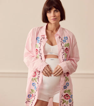Pregnant woman wearing pink lounge shirt