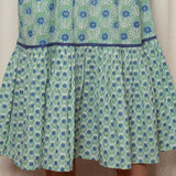 Green dress with blue floral pattern on a beige background