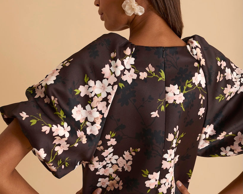 Model wearing floral puff sleeve tiered midi dress in chocolate blossom print.