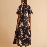 Model wearing floral puff sleeve tiered midi dress in chocolate blossom print.