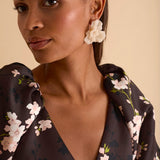 Model wearing floral puff sleeve tiered midi dress in chocolate blossom print.