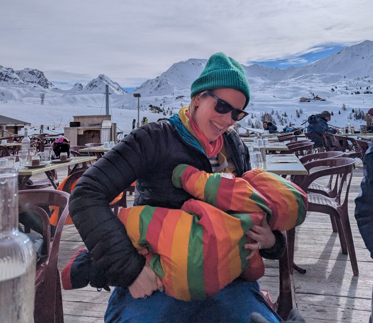 A woman breastfeeding in public by a ski piste