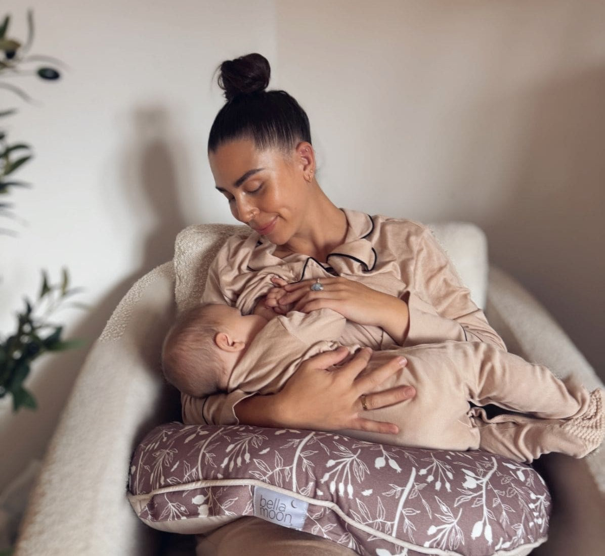 Mum breastfeeding her baby using a nursing pillow and wearing a nursing bra.