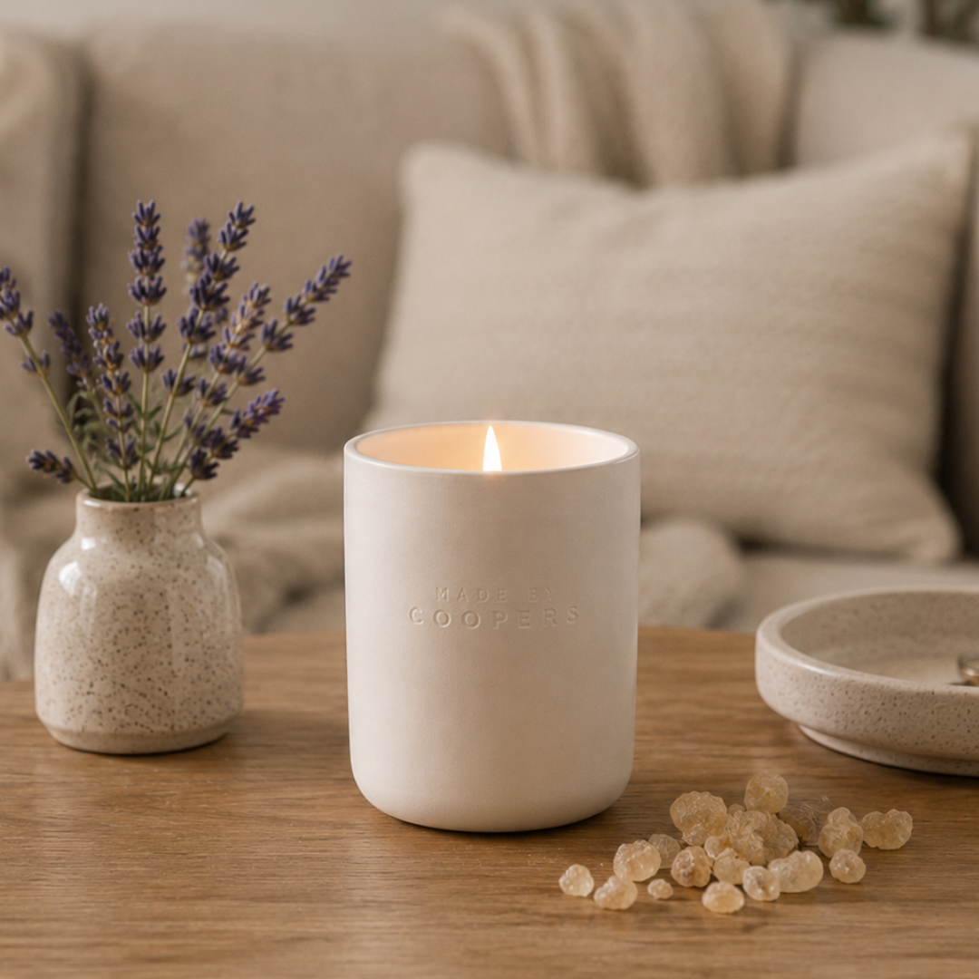 Made By Coopers Sleepy Head natural scented candle lit on a table beside lavender and frankincense