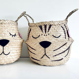 Natural Tiger Belly Basket, close-up of the tiger face with stripes, shut eyes and black nose beside another face basket