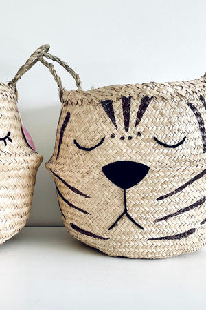 Natural Tiger Belly Basket, close-up of the tiger face with stripes, shut eyes and black nose beside another face basket