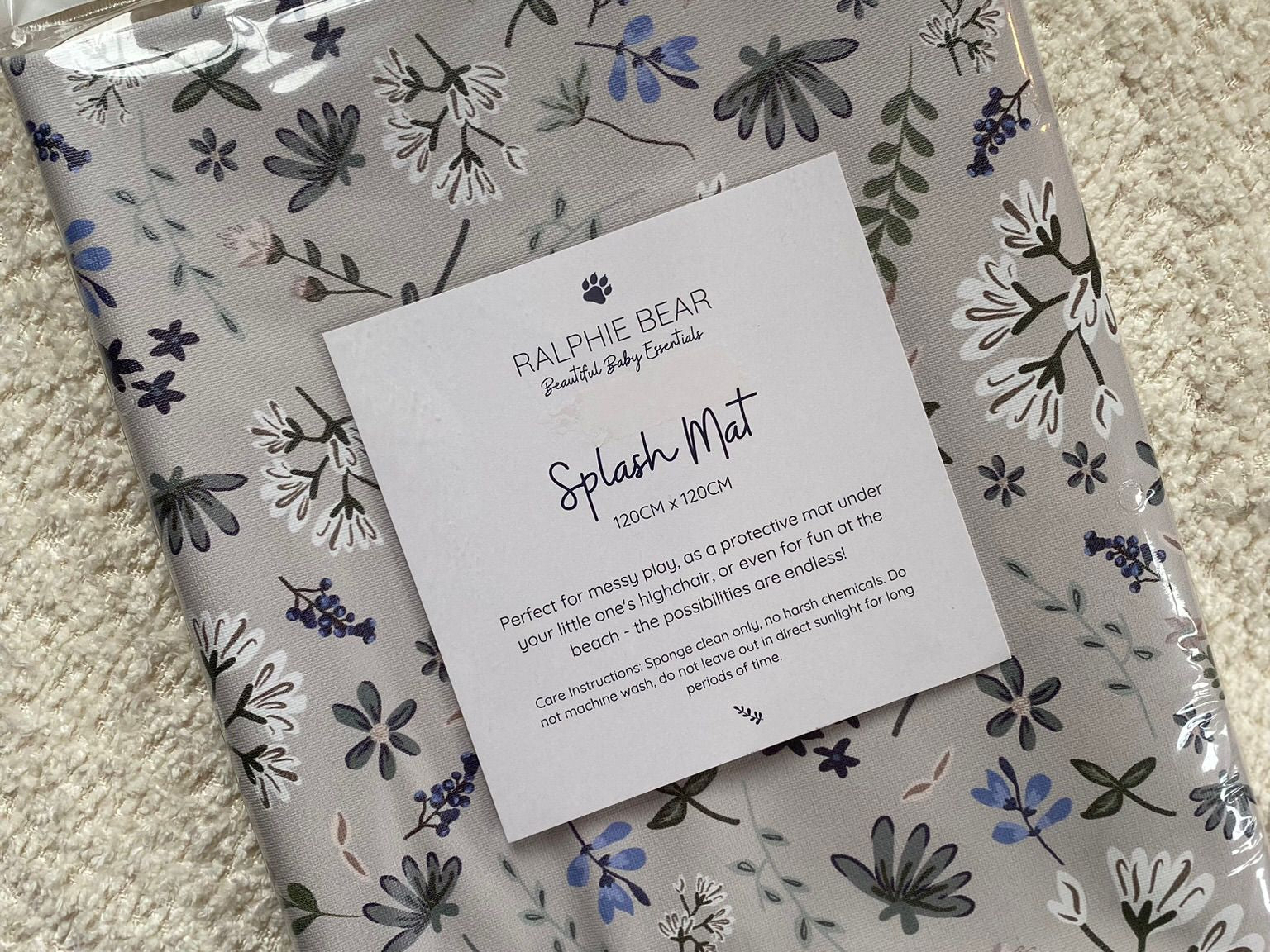 Ralphie Bear floral splash mat packaging on a carpeted floor