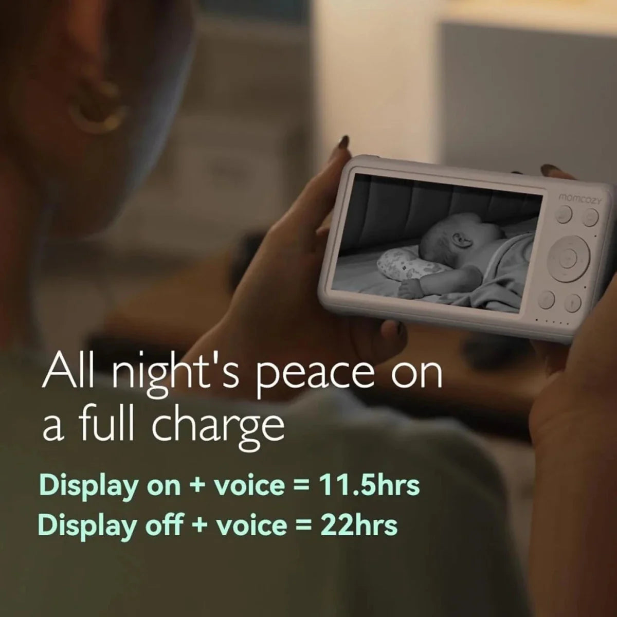 Person holding a baby monitor with text about battery life and features.
