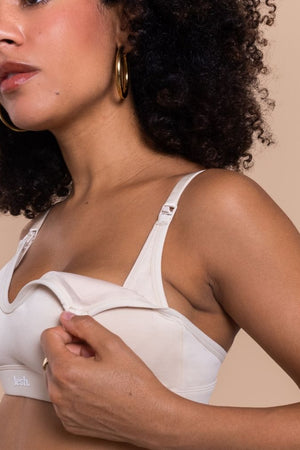 Woman wearing a white bra against a beige background