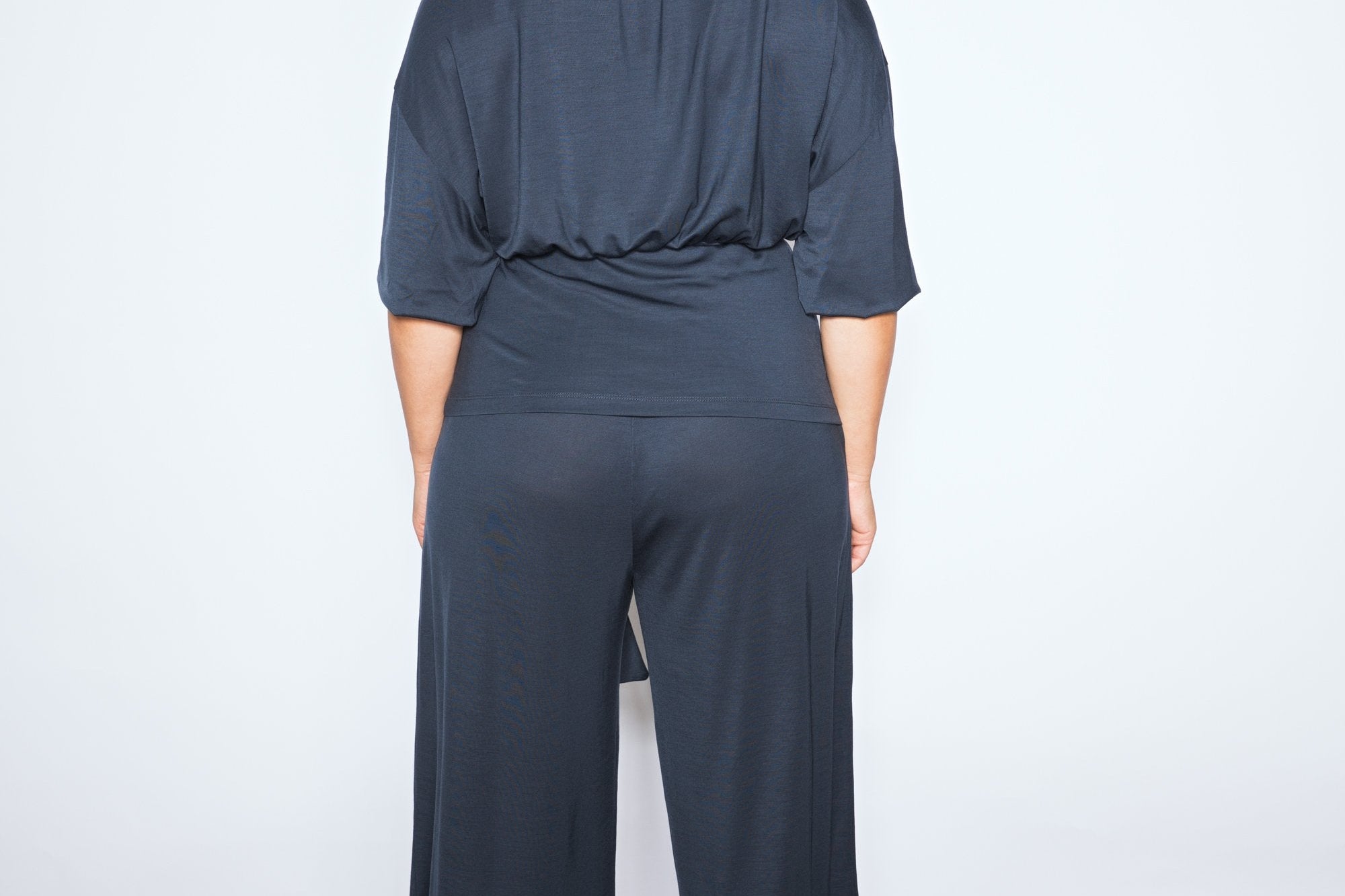 Person wearing a dark blue outfit against a white background