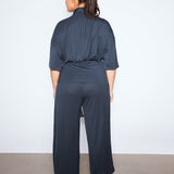 Person wearing a dark blue outfit against a white background