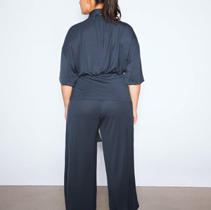 Person wearing a dark blue outfit against a white background