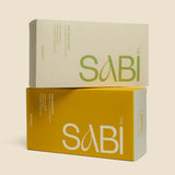 Two 'The Sabi' boxes, one beige and one yellow, on a beige background.