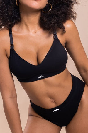 Person wearing a black bikini with 'leeh.' branding on a beige background