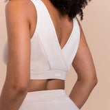 White sports bra with 'flesh' branding on a beige background
