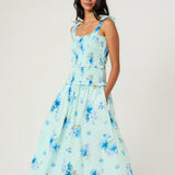 Woman wearing a light blue floral dress on a white background
