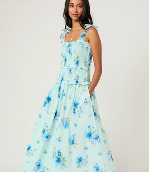 Woman wearing a light blue floral dress on a white background