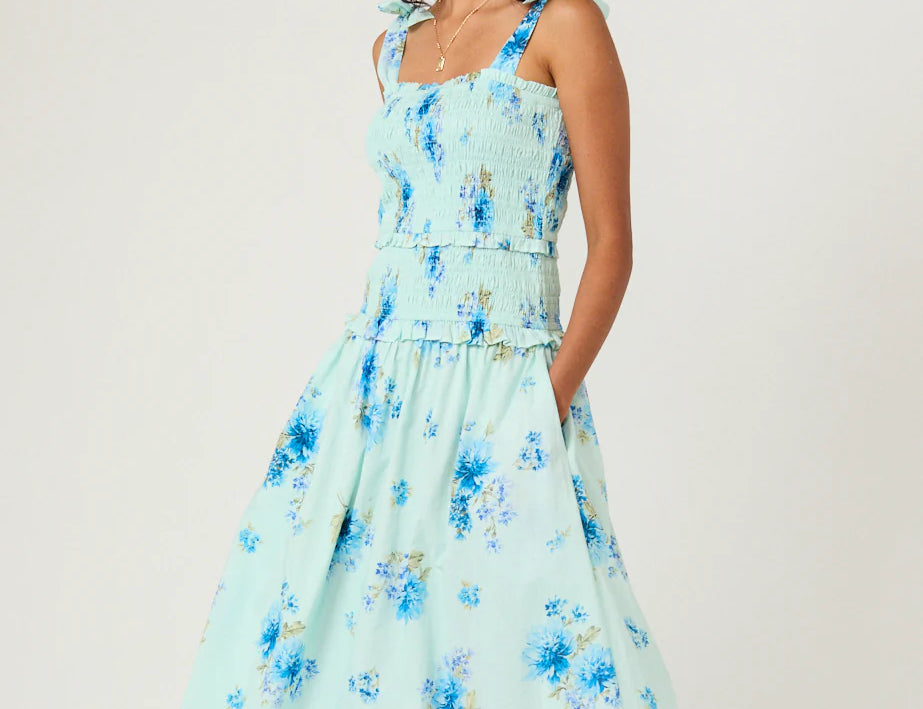 Woman wearing a light blue floral dress on a white background