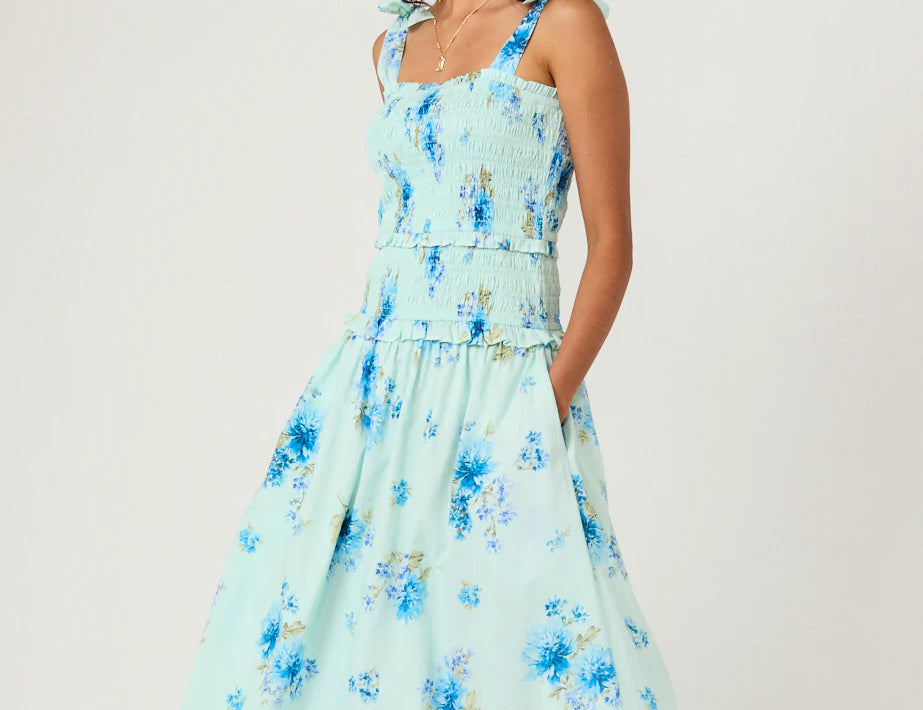 Woman wearing a light blue floral dress on a white background