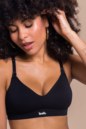 Woman wearing a black bralette with 'lesh' branding on a beige background