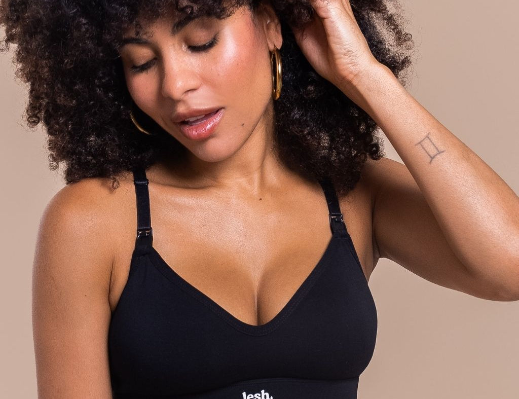 Woman wearing a black bralette with 'lesh' branding on a beige background