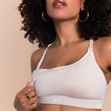 Woman wearing a beige bralette with 'lesh' branding on a beige background