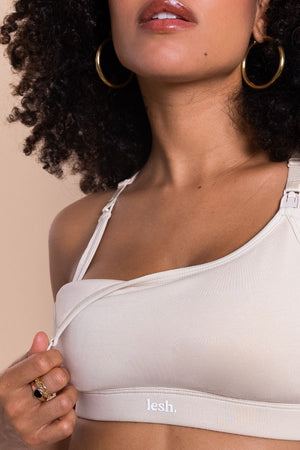 Woman wearing a beige bralette with 'lesh' branding on a beige background