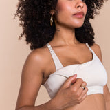 Woman wearing a white bra against a beige background