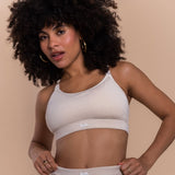 Woman wearing a white sports bra and underwear set with 'lesh' branding on a beige background