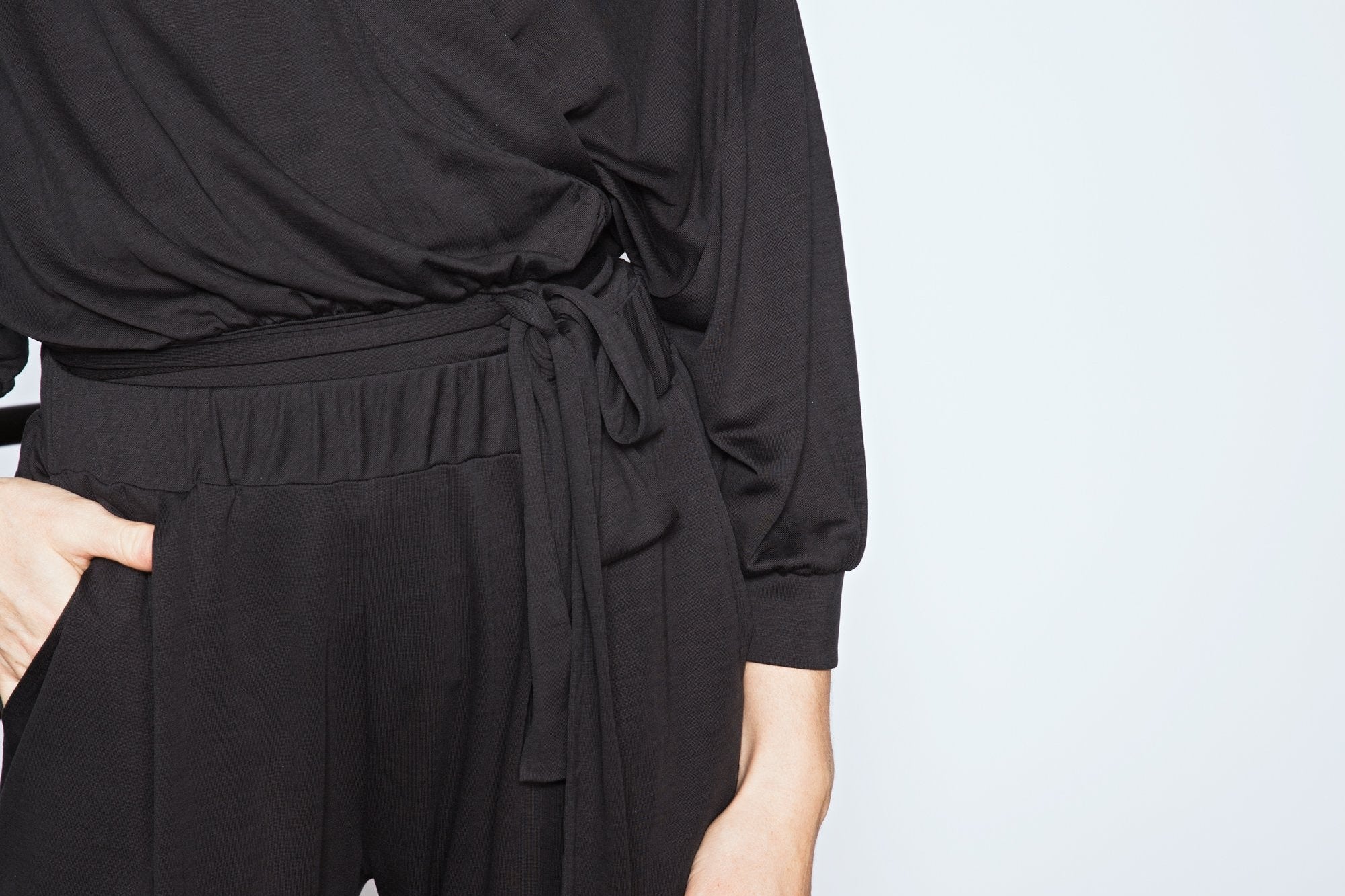 Person wearing a black outfit with a plain background