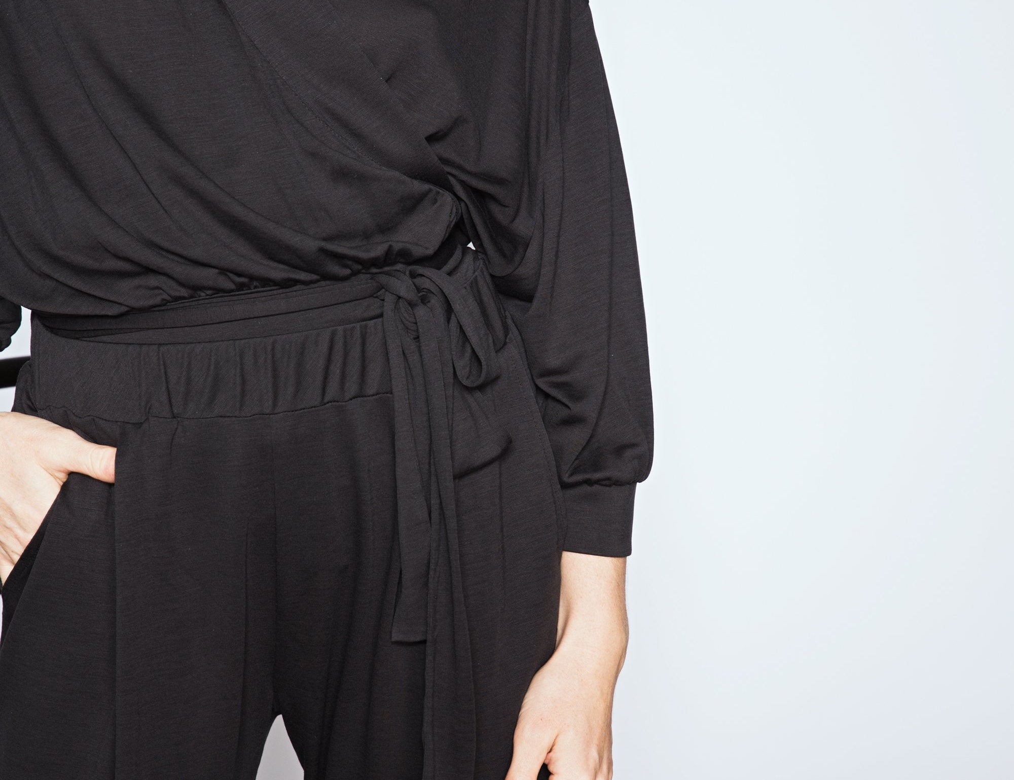Person wearing a black outfit with a plain background