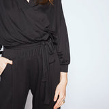 Person wearing a black outfit with a plain background