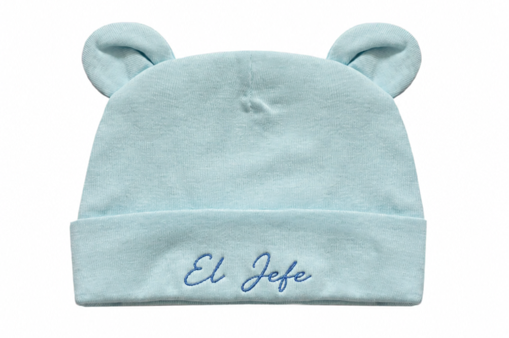 Light blue baby hat with bear ears and 'El Jefe' embroidery on a white background