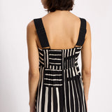 Black and white striped dress with suspenders on a plain background