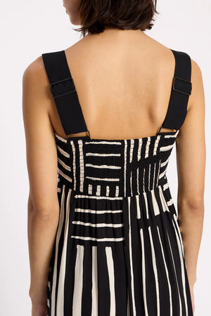 Black and white striped dress with suspenders on a plain background