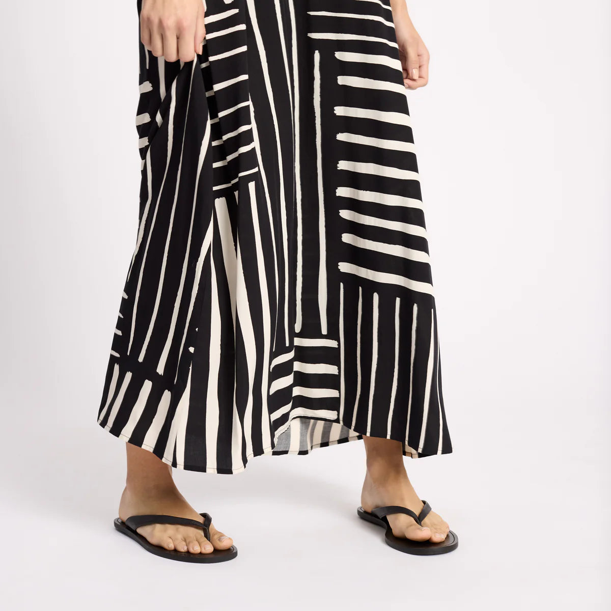 Black and white striped dress worn by a person on a white background