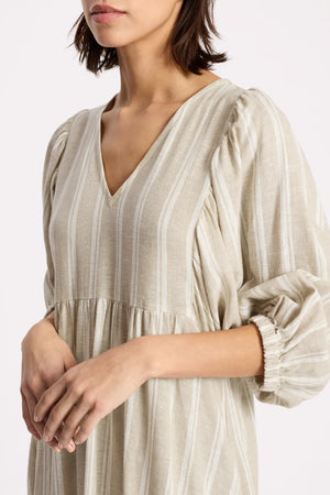 Woman wearing a beige striped dress on a white background