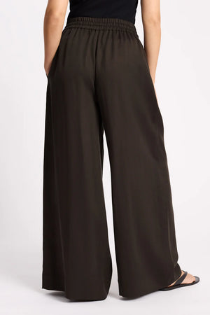 Brown wide-leg pants worn by a person on a light gray background