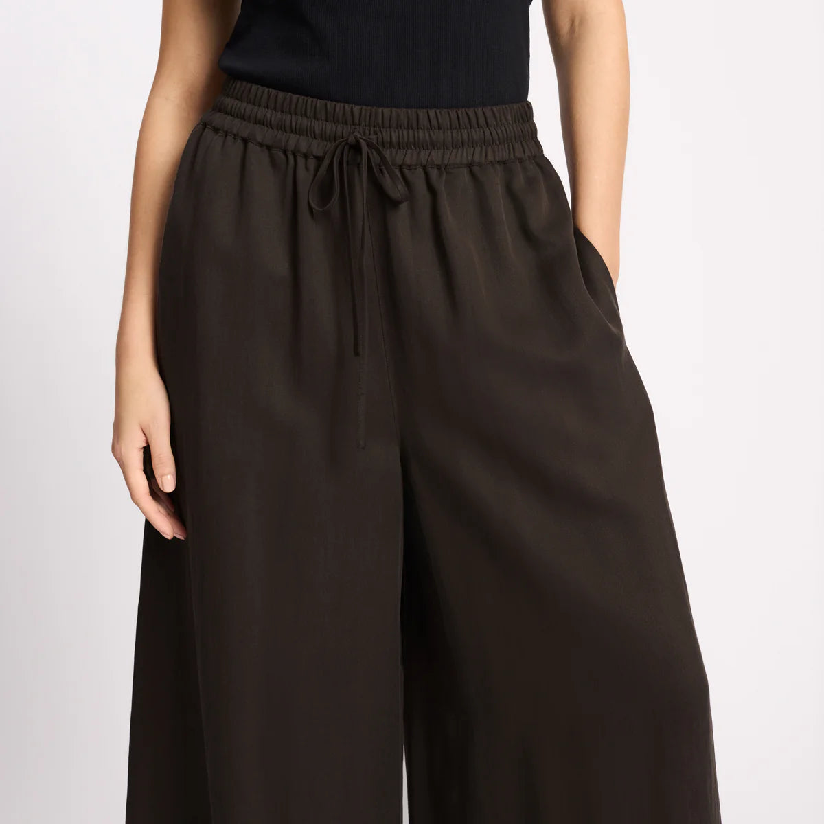 Brown wide-leg pants worn by a person on a light gray background