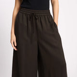 Brown wide-leg pants worn by a person on a light gray background