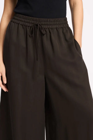 Brown wide-leg pants worn by a person on a light gray background