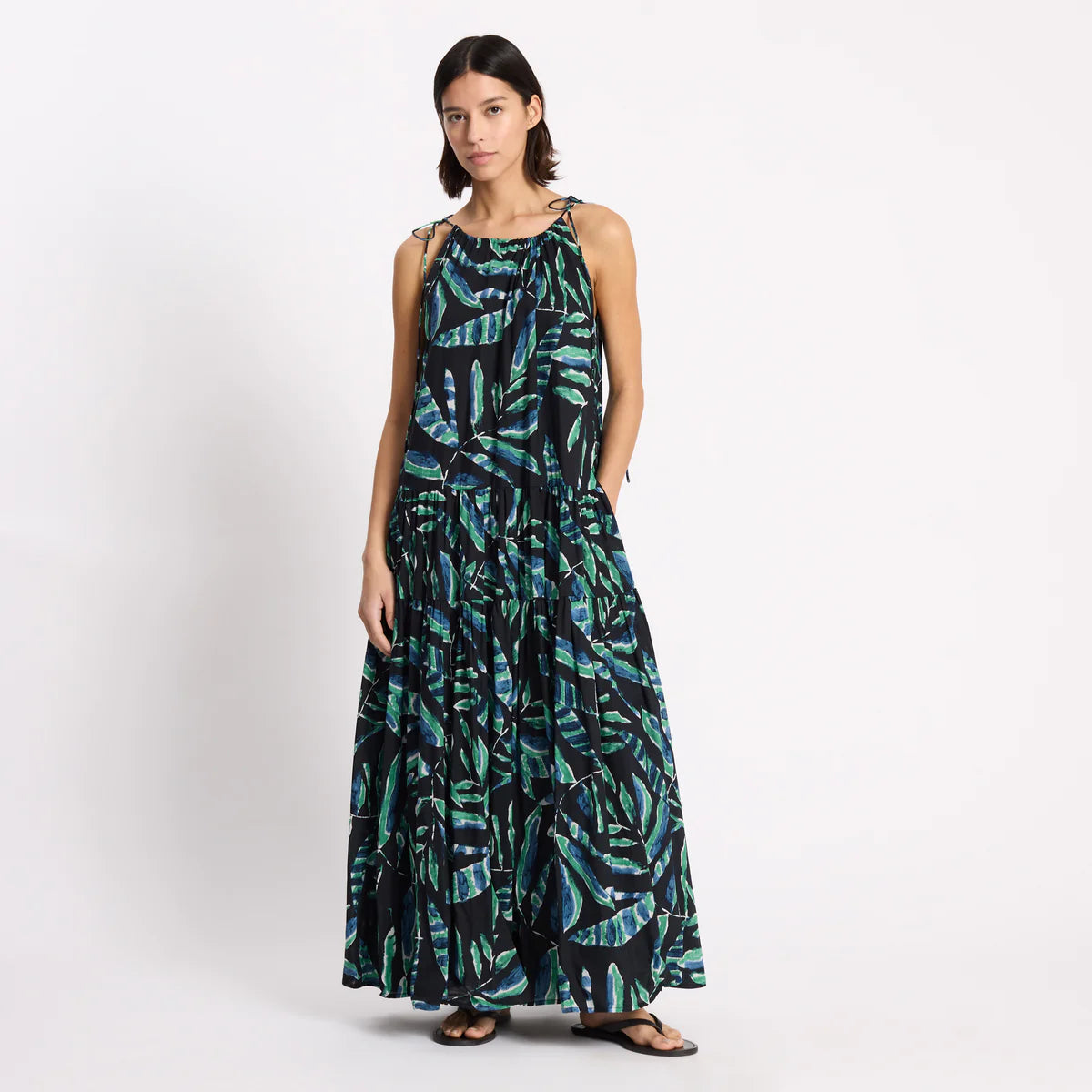 Woman wearing a long, patterned dress on a white background