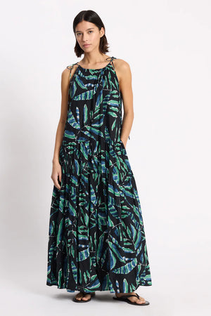 Woman wearing a long, patterned dress on a white background