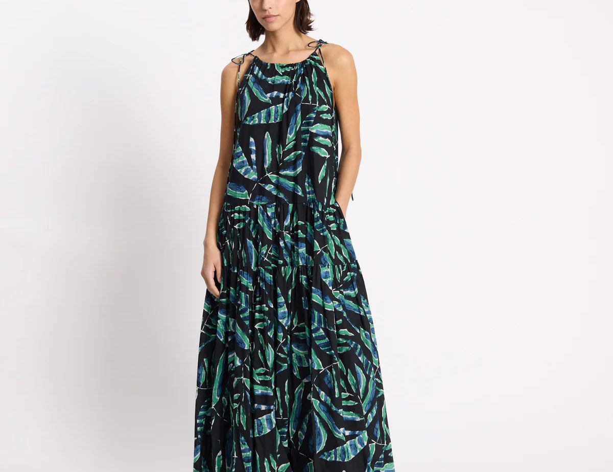 Woman wearing a long, patterned dress on a white background