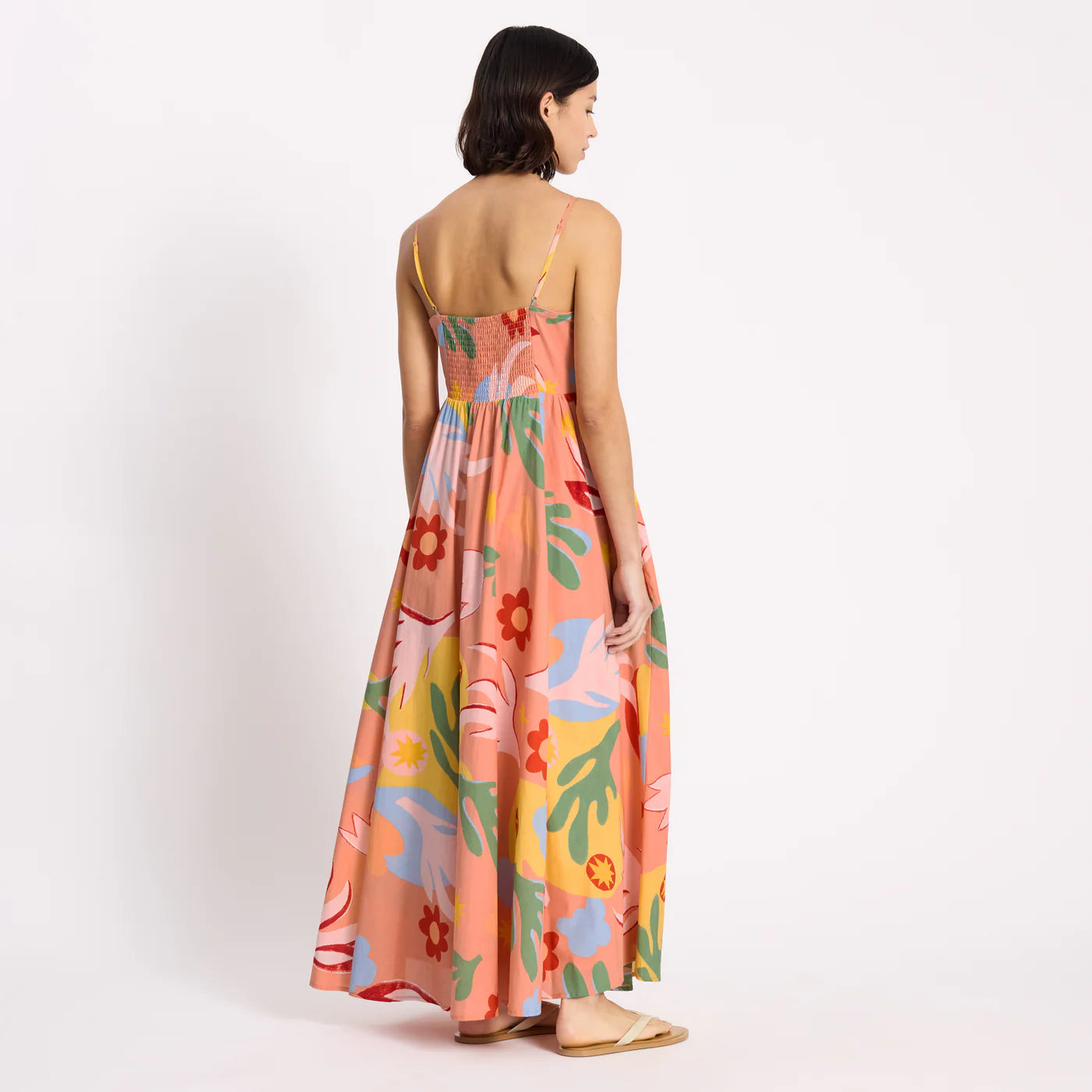 Woman wearing a colorful floral dress on a white background