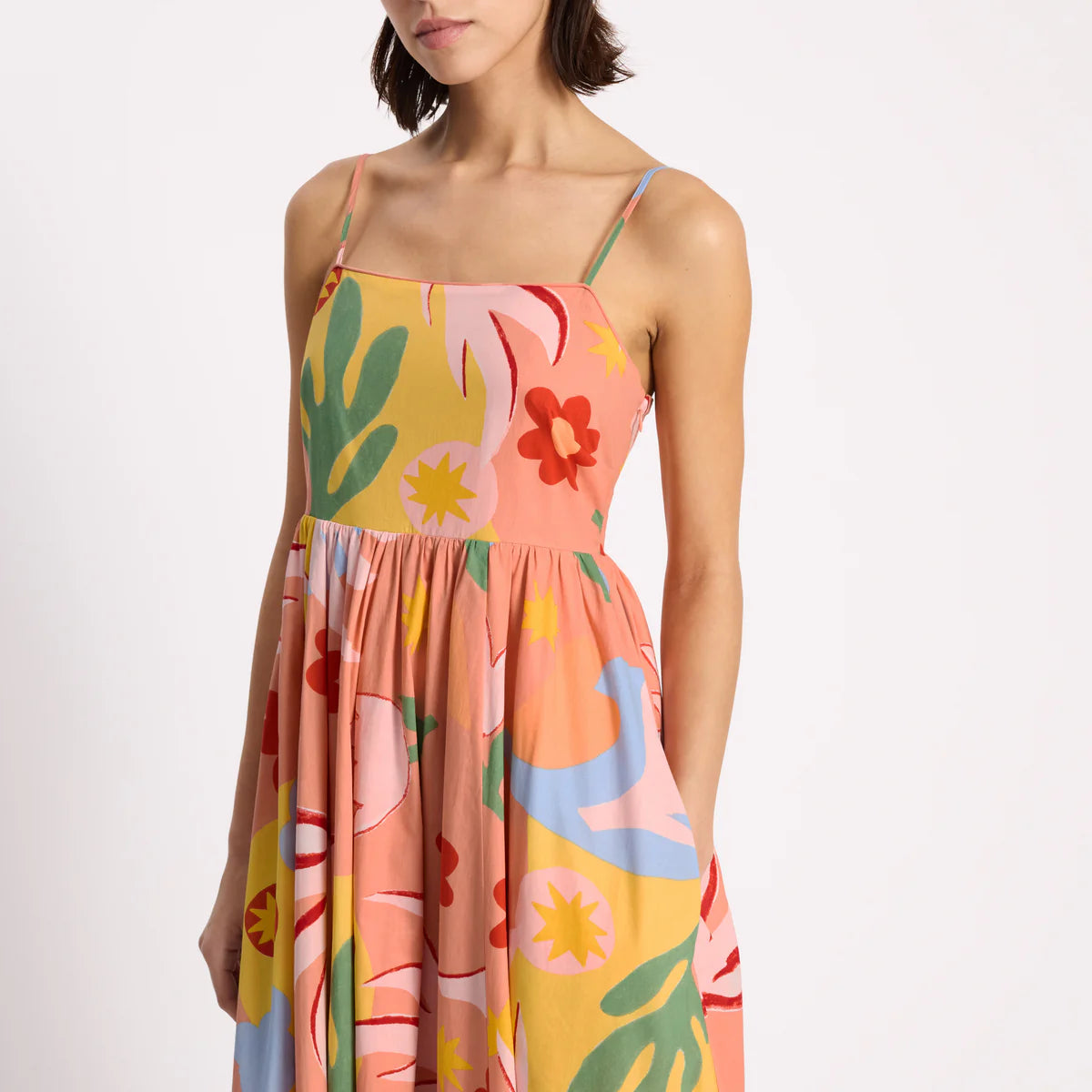 Woman wearing a colorful floral dress on a white background