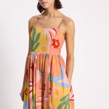 Woman wearing a colorful floral dress on a white background