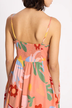 Woman wearing a colorful floral dress with a plain background