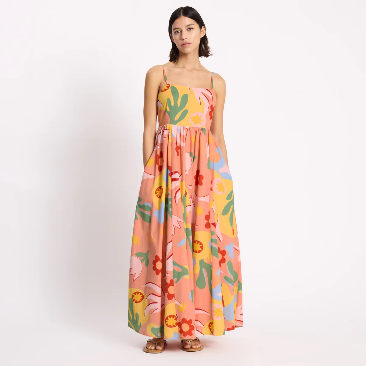 Woman wearing a colorful floral dress on a white background